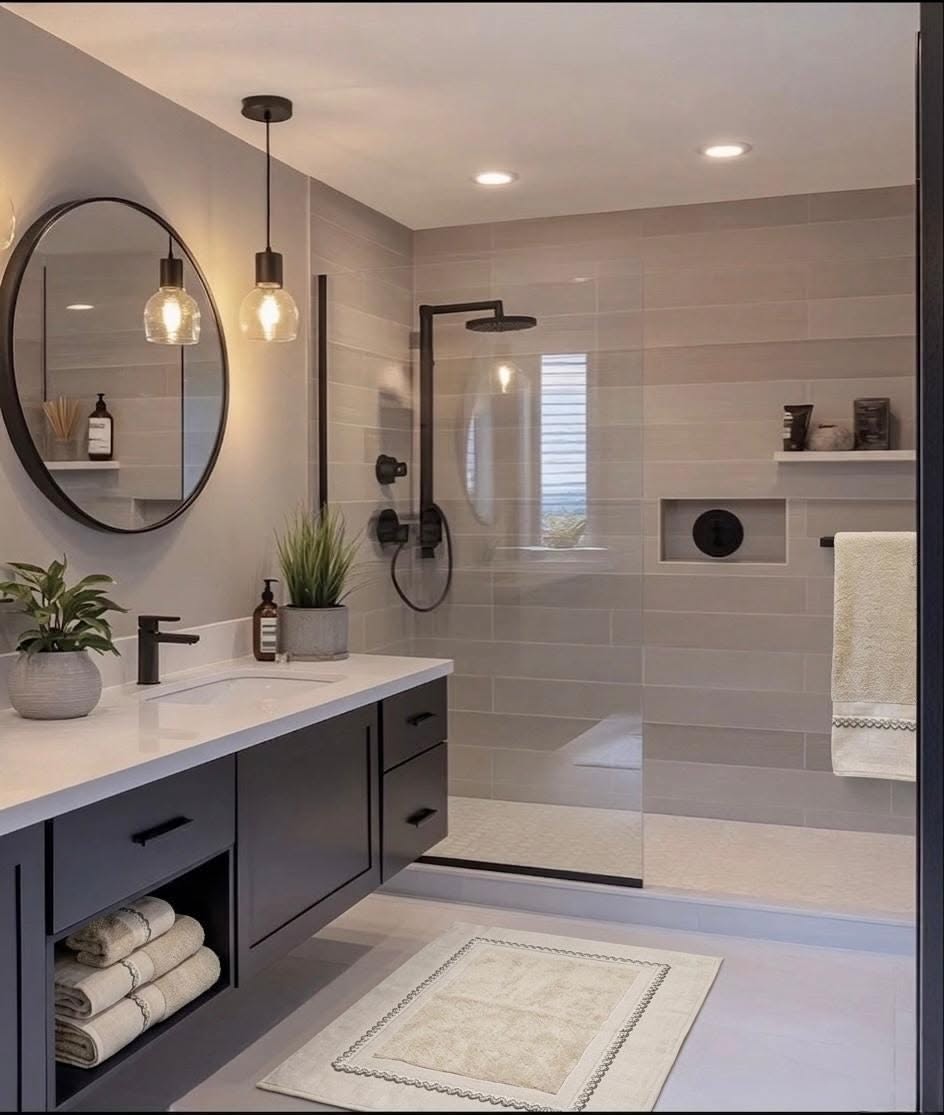 Modern bathroom with charcoal grey tiles, frameless glass walk‑in shower, matte black fixtures, and recessed lighting.