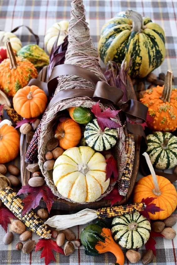 Farmhouse kitchen island, white pumpkin cornucopia, red‑black checkered tablecloth, wooden stools, daylight.