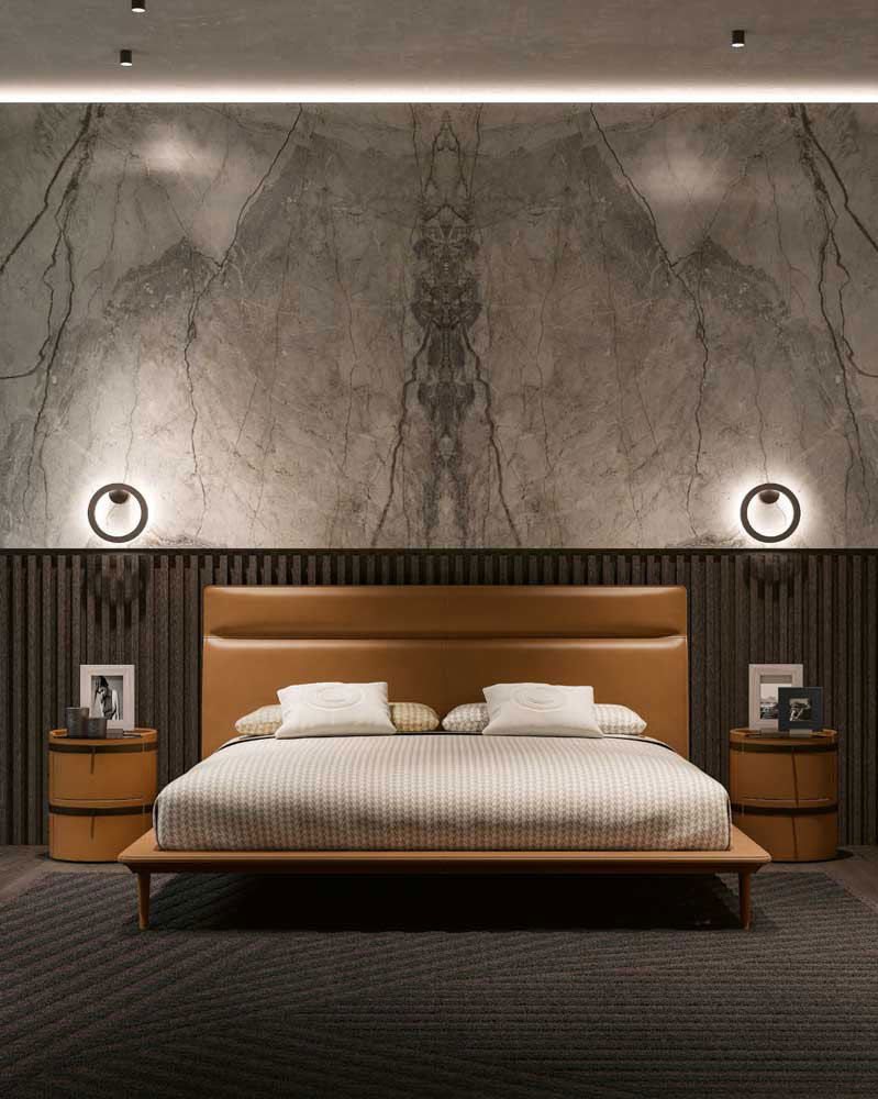 Warm master bedroom with terracotta accent wall, slubbed linen bedding, natural wood nightstand, soft golden lighting.