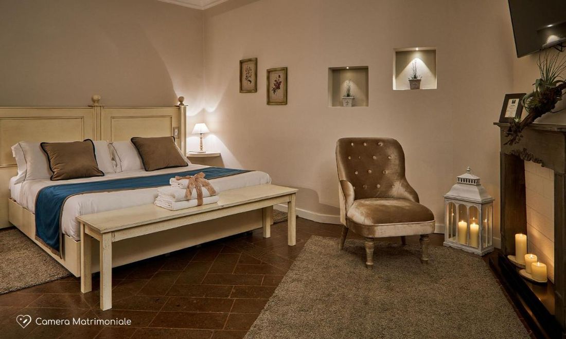 Couples bedroom with dusty rose boucle headboard, plaster walls, and warm indirect cove lighting.