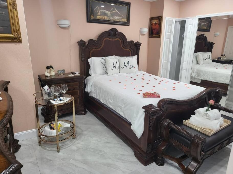 Coastal couples bedroom featuring woven rattan headboard, crisp white linen, dim amber woven lamps.