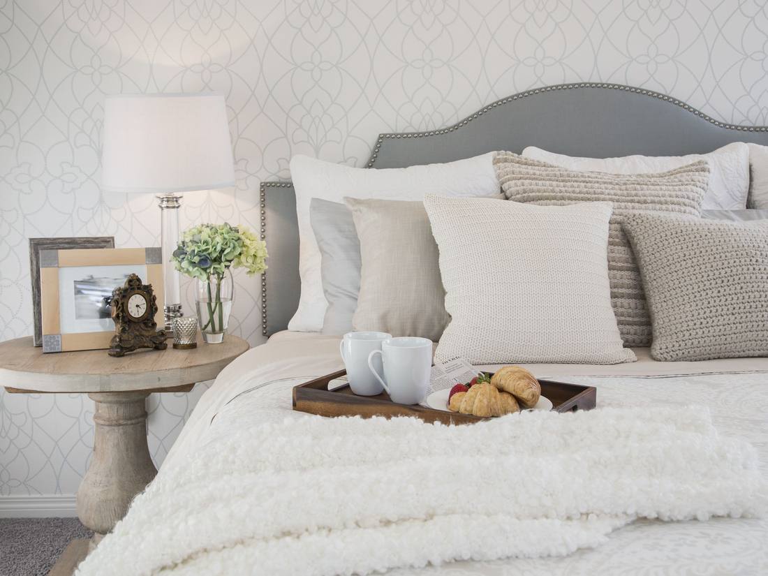 Glamorous couples bedroom with deep plum accent wall, brushed brass bed frame, warm crystal pendants.