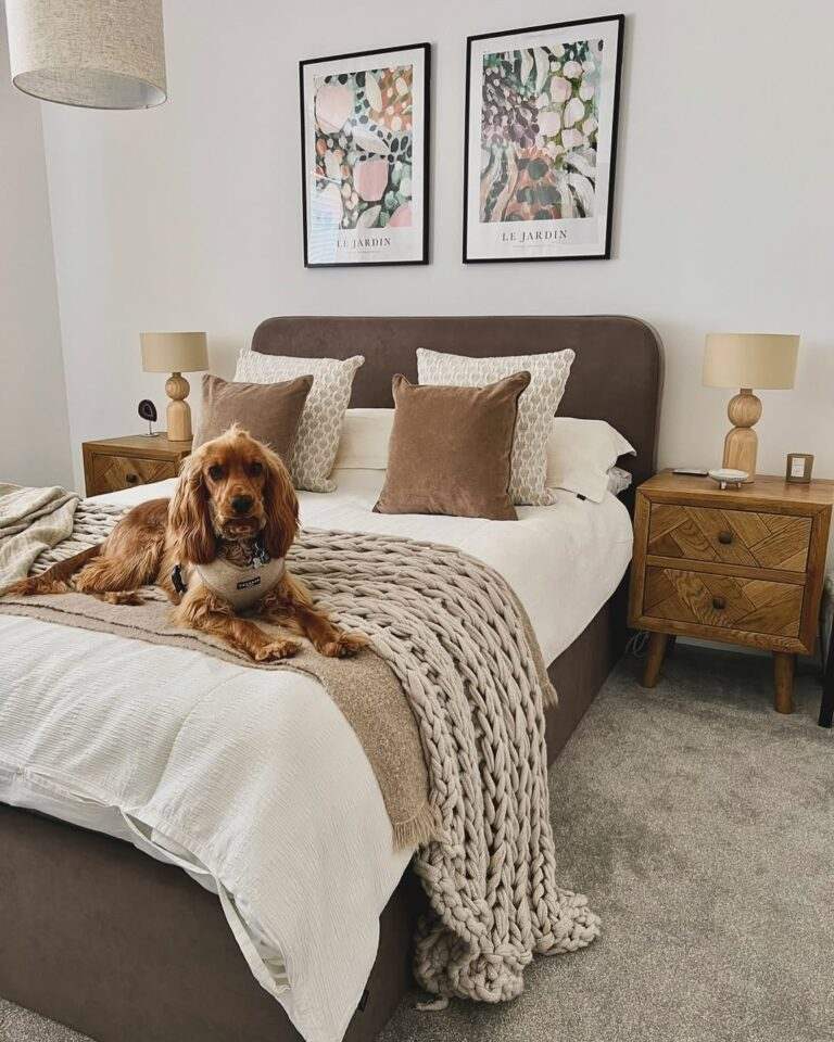 Couples bedroom with plum velvet upholstered bed brass sconces and charcoal grey walls under warm lighting