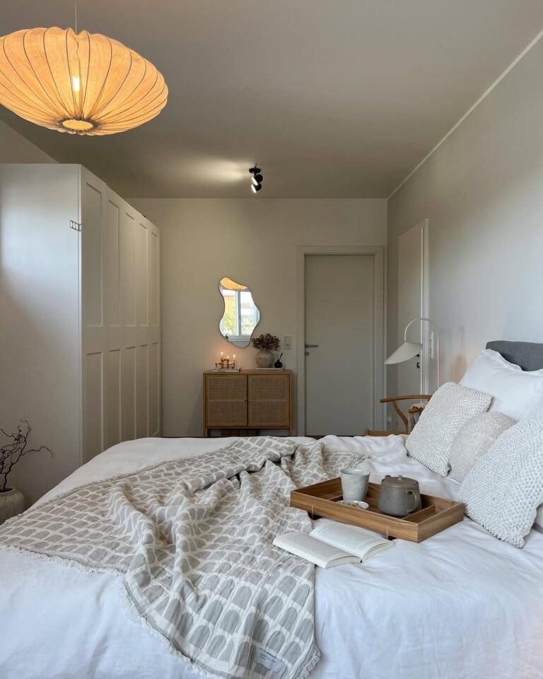 Couples bedroom featuring low oak platform bed woven cane headboard warm terracotta walls soft pendant light