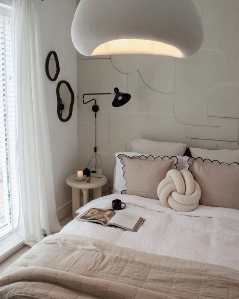 Romantic couples bedroom with classic wall picture moulding champagne silk curtains tufted bench warm ambient lighting