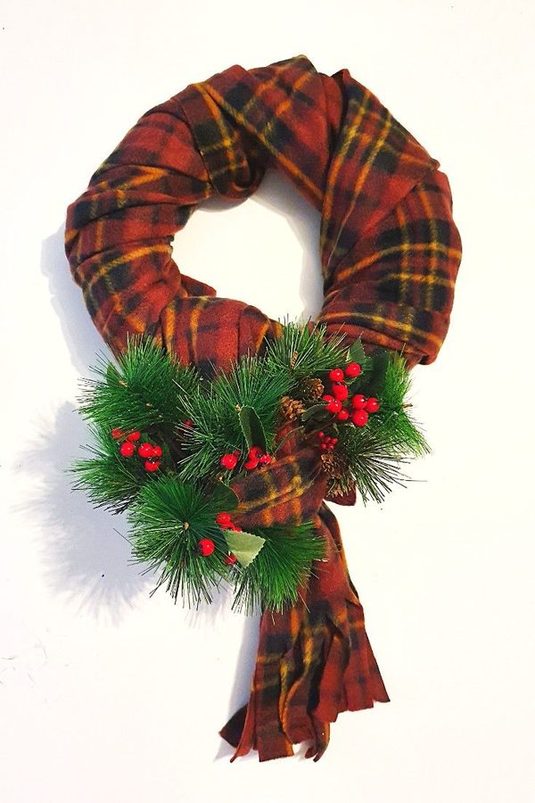 Deep emerald green plush scarf wreath on a gold brass framed wall mirror in hallway