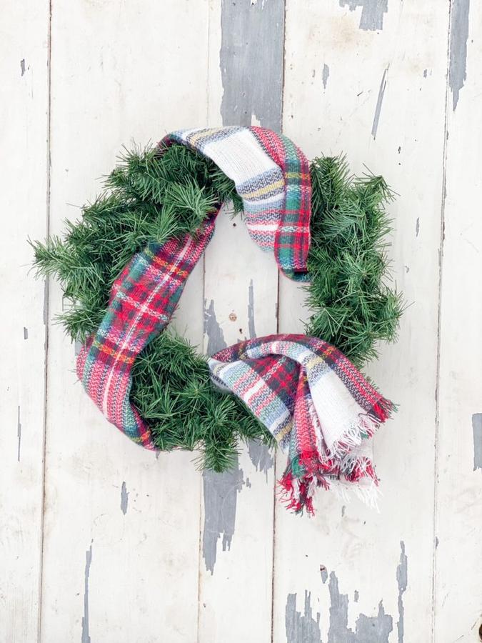 Blush pink soft fleece scarf wreath hanging over a white beadboard entryway bench wall