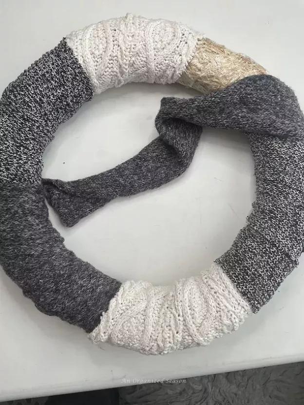 Scandinavian dining room showing white fleece scarf wreath on glass window with soft warm backlight.