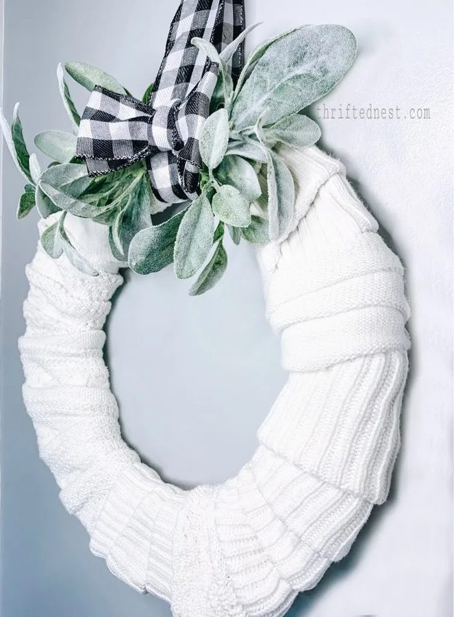Home office gallery wall showcasing oatmeal cashmere scarf wreath mounted above light wood writing desk.