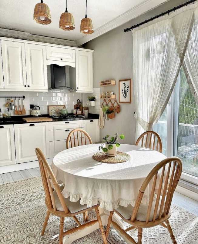 Kitchen nook with round wooden table, upholstered bench, soft pendant lighting, pastel walls.