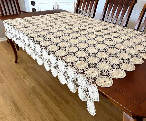 Dining room table with crochet table decorations, geometric patterns, charcoal gray, bright daylight.