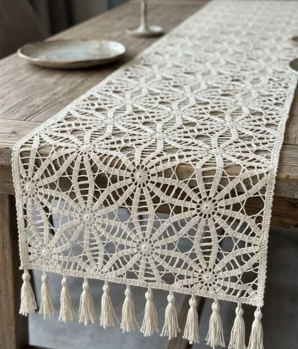 Kitchen dining table with black and white crochet runner, farmhouse decor, wooden bowls, natural light.