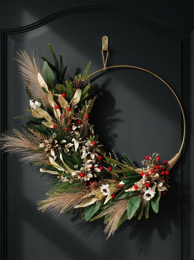 Boho vanity accent featuring slim brass ring wreath, muted pink dried hydrangeas, oak desk, warm glow lamp