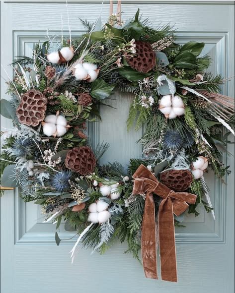 Cozy bedroom with boucle armchair, white wreath with dried flowers, soft lighting, neutral decor.