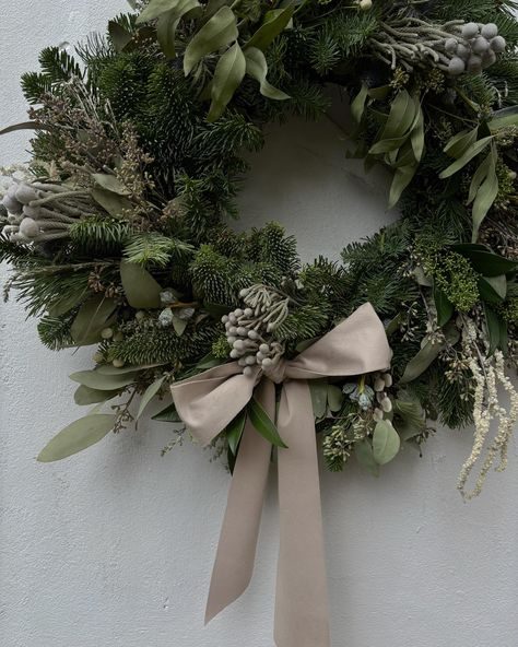 Kitchen breakfast nook, rattan star wreath, cotton stems, white walls, bright morning light.