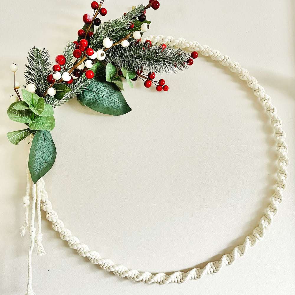 Boho bedroom headboard area, warm sconce light, gold hoop wreath with mustard velvet ribbon and ferns.