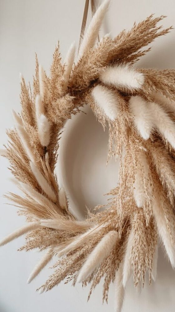Bohemian hall with a wooden bead wreath with dried palm spears above a raw timber console.