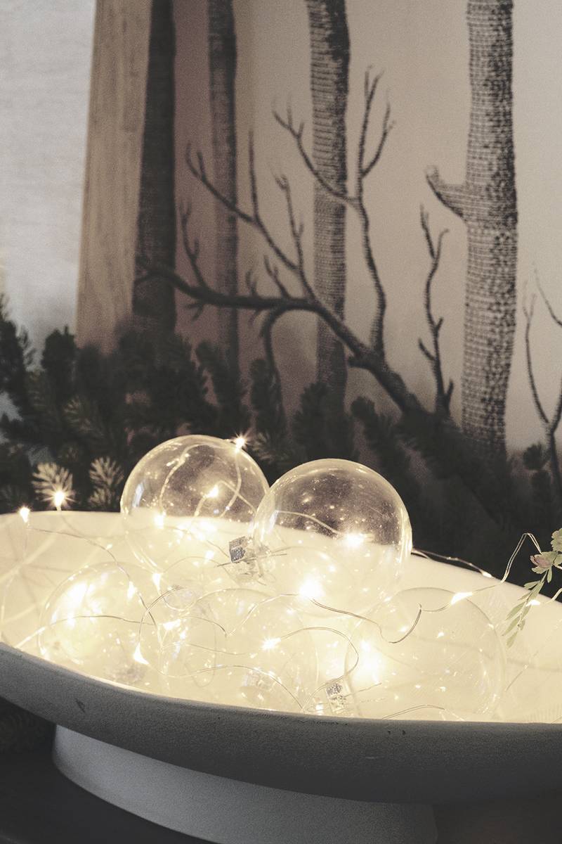 Living room side table displaying emerald green velvet padded NOEL marquee letters with mini frosted bulbs.