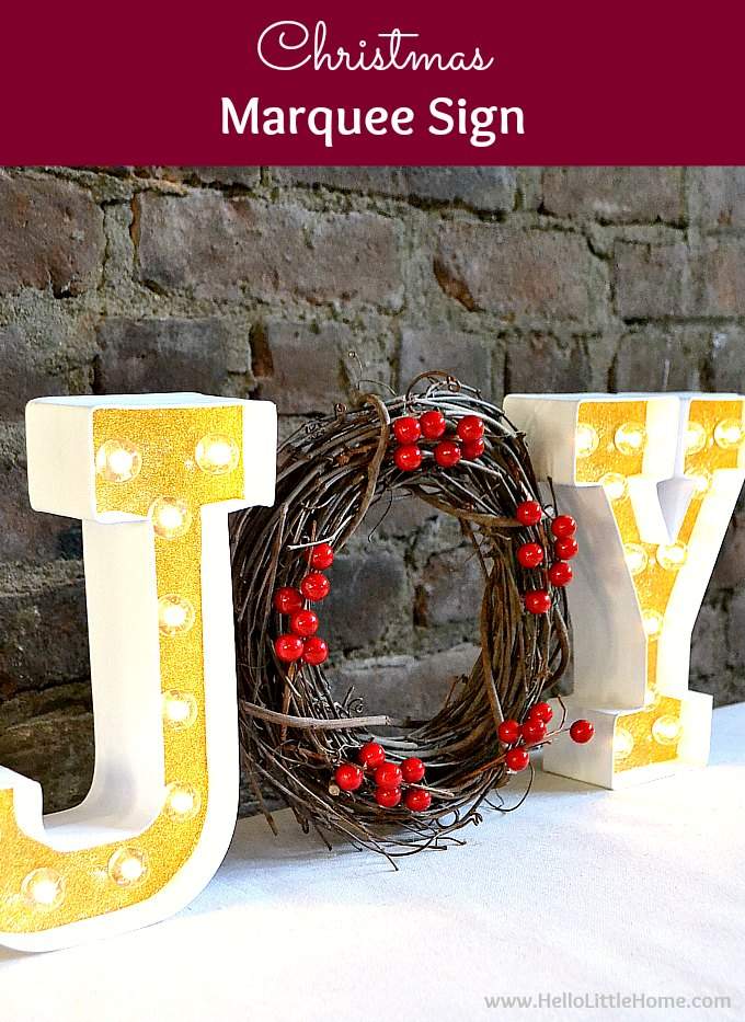 Grand staircase landing decorated with large white HO HO HO marquee letters and green garland.