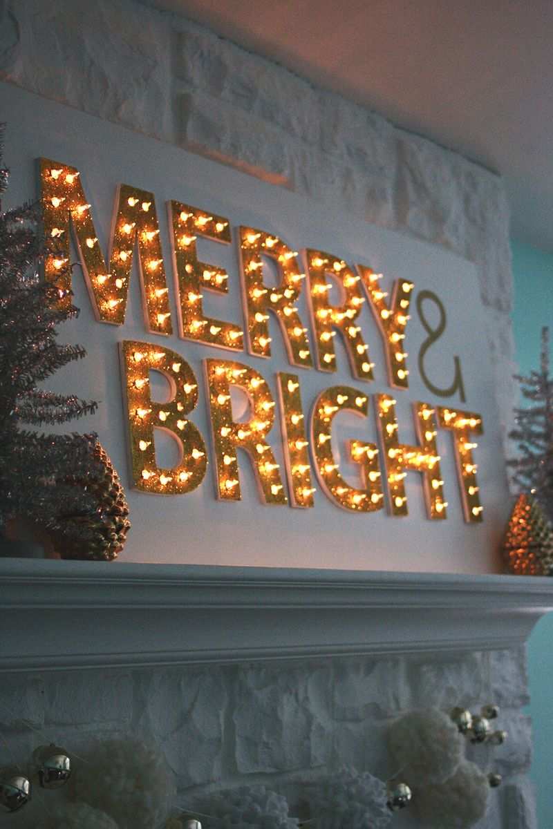 Industrial dining room featuring oversized black iron Christmas tree marquee with warm white bulbs.