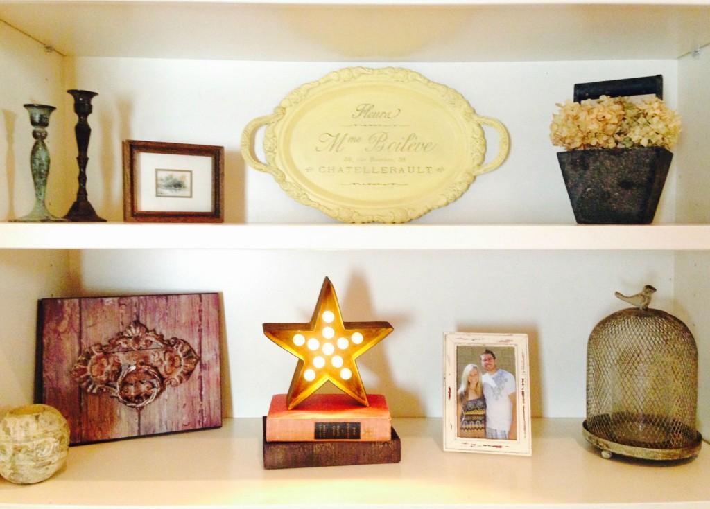 Small apartment living room wall adorned with a twig and globe light marquee tree silhouette.