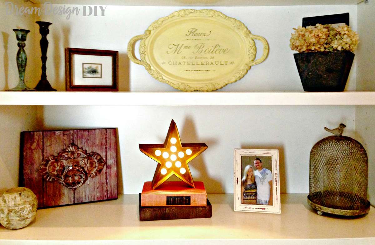 Modern home office bookshelf styled with clear acrylic MERRY marquee light letters and pine stems.