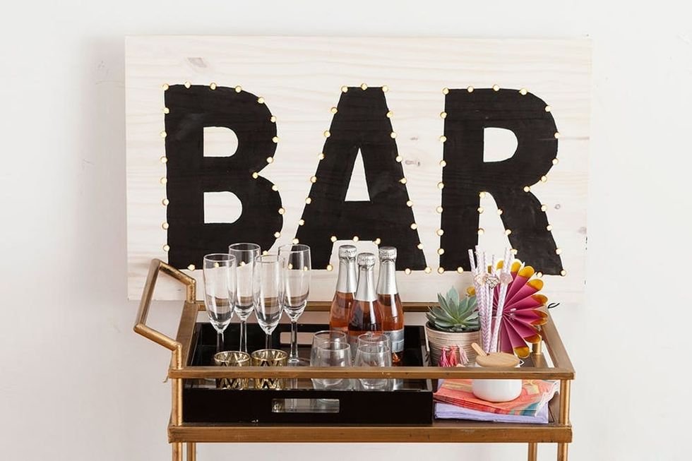 Great room fireplace flanked by large galvanized metal angel wings marquee light art piece.