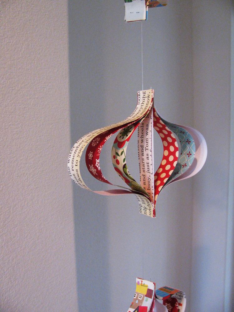 Hallway display with numbered paper origami pyramid boxes, driftwood branch, soft warm twinkle lighting.