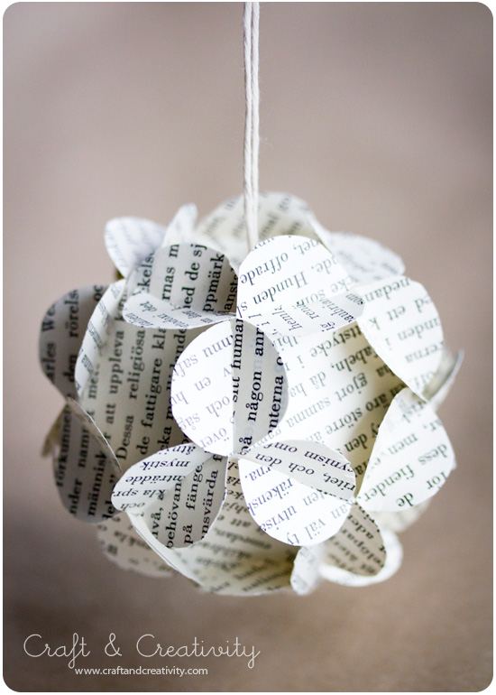 Elegant holiday dining table place setting with folded origami paper angel, linen napkin, ceramic plate, gold cutlery.