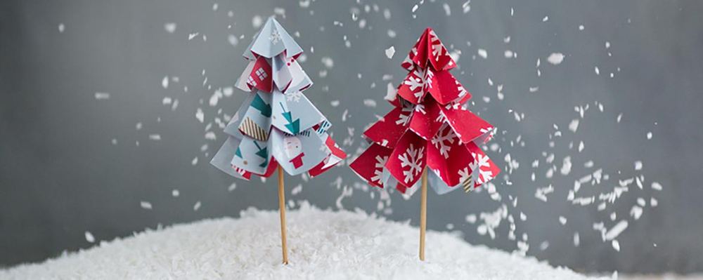 Elegant holiday dining setup with linen napkin, ceramic plate, and folded paper origami star accent.