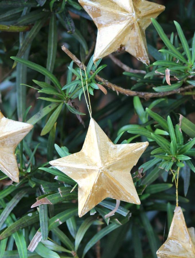 Entryway hallway displaying natural wooden bead star ornament hanging on crisp white door with warm lighting.