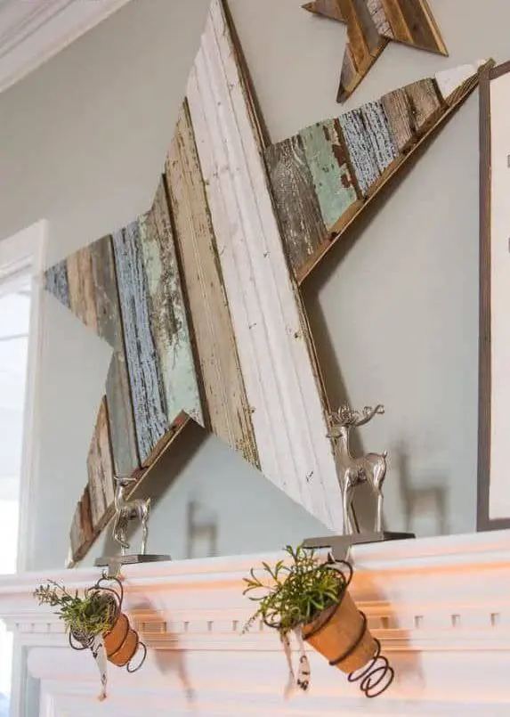 Cozy bedroom with reclaimed wood diy christmas star decorations hanging over a neutral upholstered bed and cozy knits