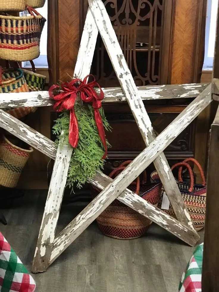Vintage living room wall displaying folded book page diy christmas star decorations with antique bronze sconce lighting