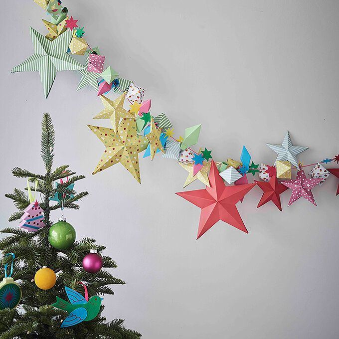 Modern dining area featuring frosted acrylic diy christmas star decorations suspended beneath sleek black track lighting