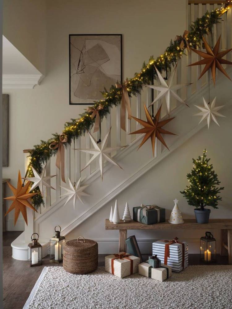 Boho bedroom displaying macrame cord diy christmas star decorations draped along a wooden wall shelf with greenery