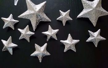 Sunny window sill draped with delicate hanging brass wire star ornaments warm ambient sunlight