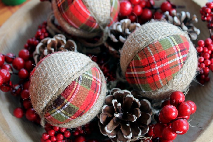 Cozy living room corner with tree adorned in soft cream chunky knit wool yarn wrapped diy christmas tree balls.