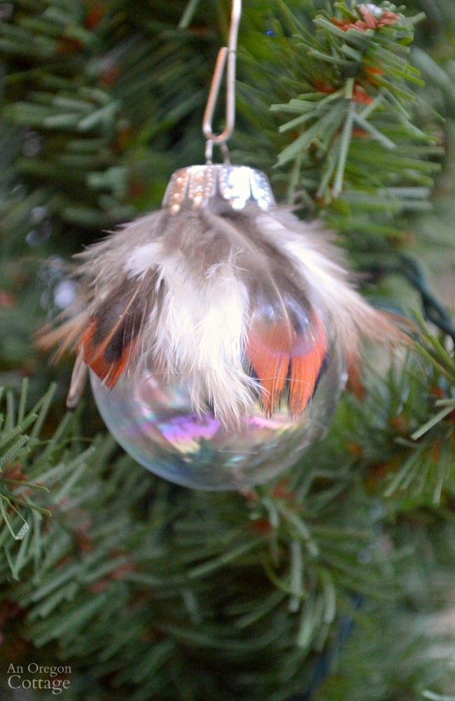 Sunlit Nordic living room pine tree decorated with clear glass pressed botanical DIY Christmas tree balls.