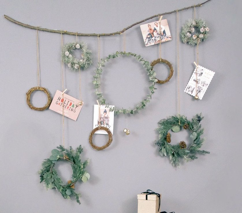 Suspended natural timber wall hanging with vertical jute twine strings holding colorful seasonal cards