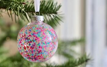 Coastal staircase banister wrapped with evergreen garland and light aqua blue ombre glass ornaments.