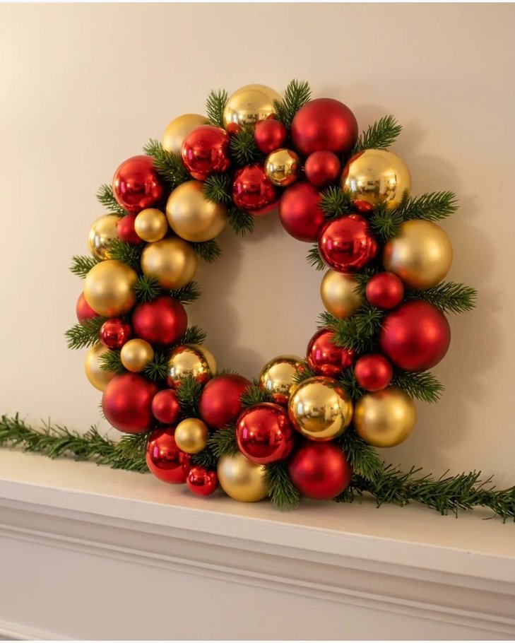 Colorful dollar store ornament wreath on white shelf with candles