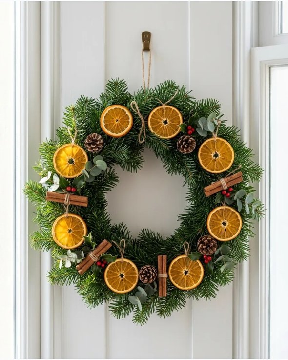 Dried orange wreath on white wall with warm lighting