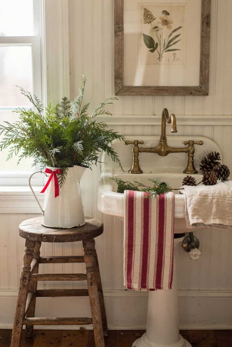Enamel pitcher, cedar branches, white bathroom, rustic holiday accent