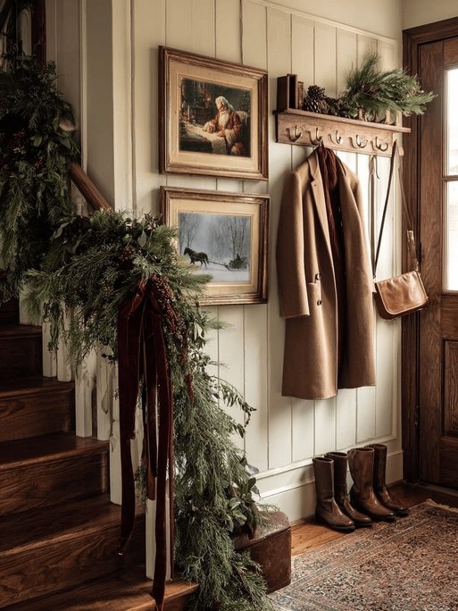 Entryway table with horse sculpture, tartan runner, brass lanterns, pinecones, warm lighting.