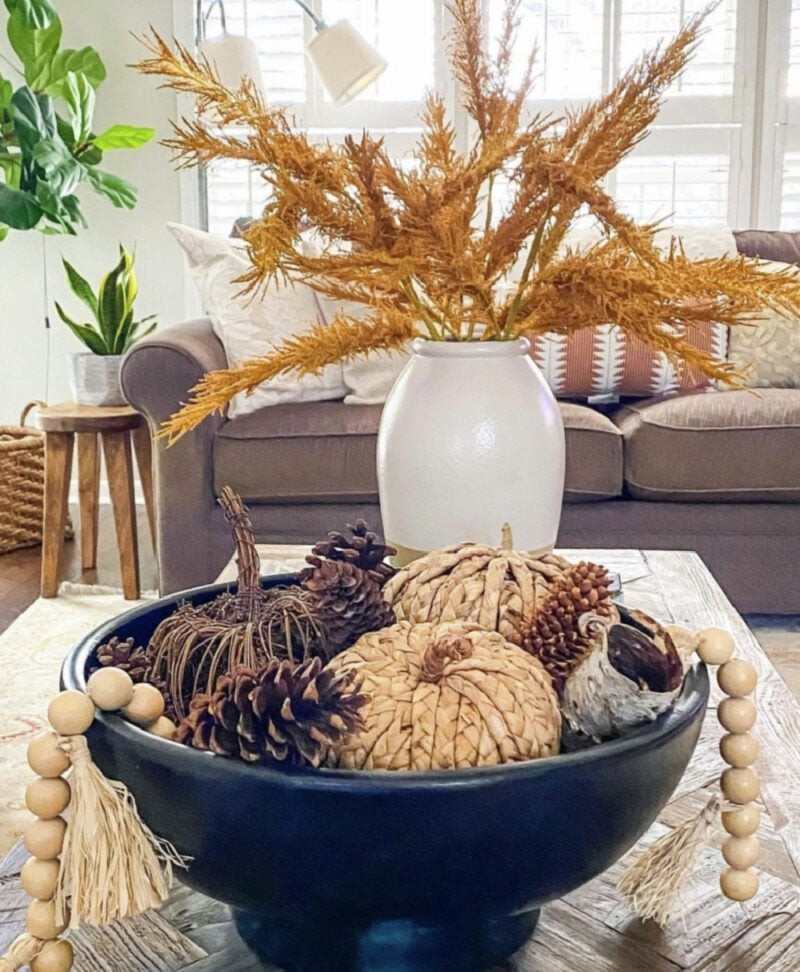 Autumn fireplace mantel decorated with heirloom pumpkins eucalyptus garland brass candleholders warm ambient glow
