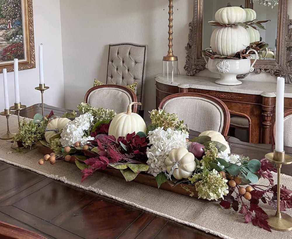 Entryway console table with rustic wooden mirror ceramic vase dried branches and warm lighting