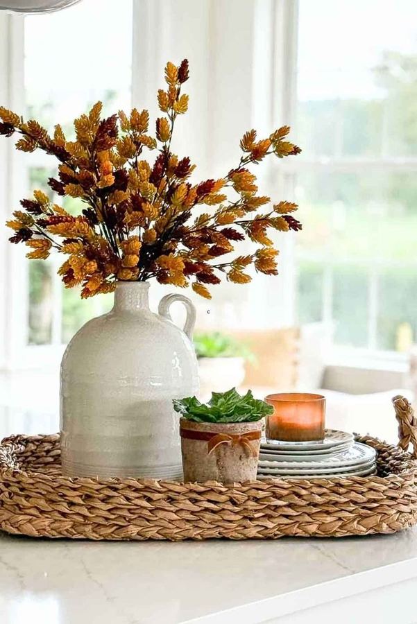 A front porch with a layered rug, mum flowers, and a wreath.