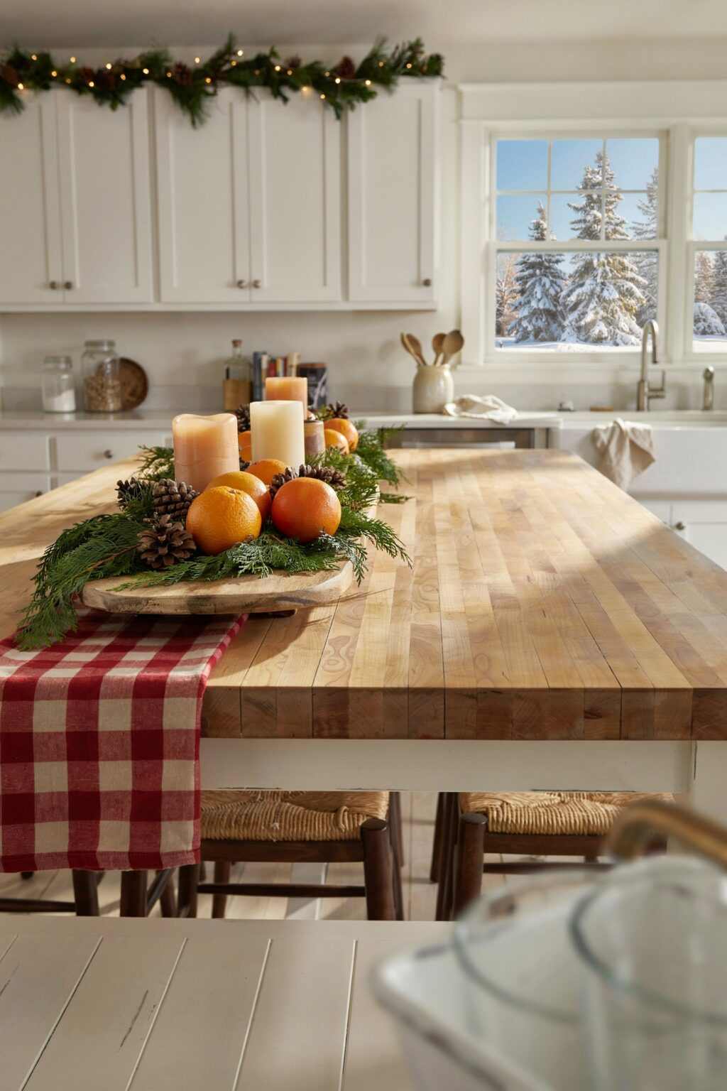 Kitchen cabinet doors decorated with small evergreen wreaths tied with classic red plaid ribbon.