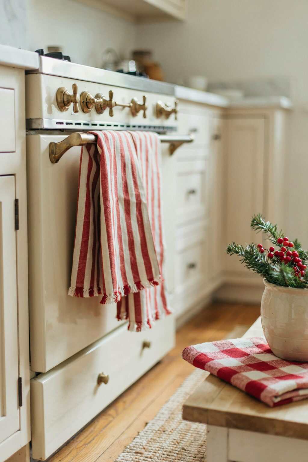 A large simple boxwood wreath hanging on a central stainless steel range hood.