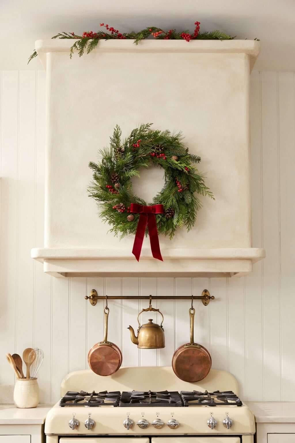 A kitchen wall rack holding holiday-themed kitchen towels and a festive apron.